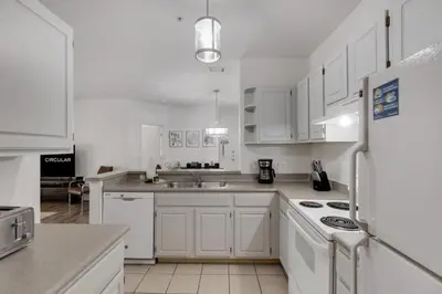 a kitchen with white cabinets and a white refrigerator at LC-8828-12-203DC - Legacy Dunes Condo for 6 guests in Kissimmee