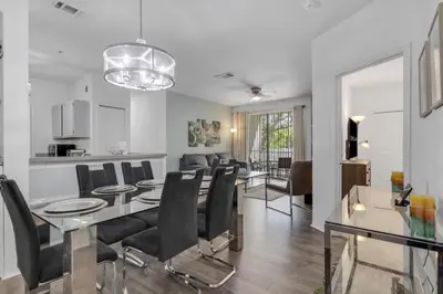 a dining room and living room with a table and chairs at LC-8828-12-203DC - Legacy Dunes Condo for 6 guests in Kissimmee