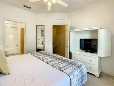 a bedroom with a white bed and a tv at LV2950-105LHC - 4 bedrooms - Lucaya Resort in Kissimmee