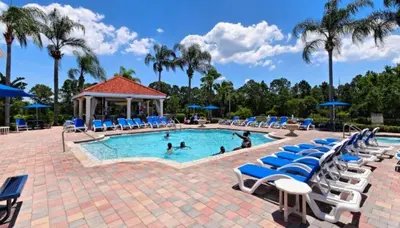 a pool with lounge chairs and people in it at EIR8505PH - Emerald's paradise by Disney in Kissimmee