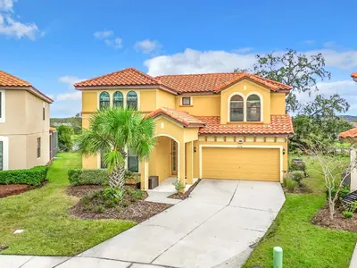 a yellow house with a garage at Tranquility Hut, Spacious 4-bedrooms, 4-bathrooms, Pools, free parking in Kissimmee