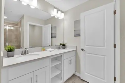 a white bathroom with a sink and a mirror at 3151 Paradox #306 in Kissimmee