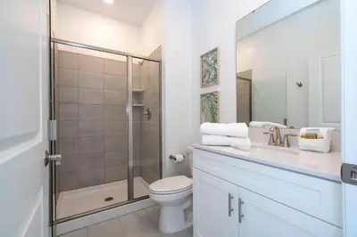 a bathroom with a shower and a toilet and a sink at Brand New Cozy Retreat at Storey Lake Resort in Kissimmee