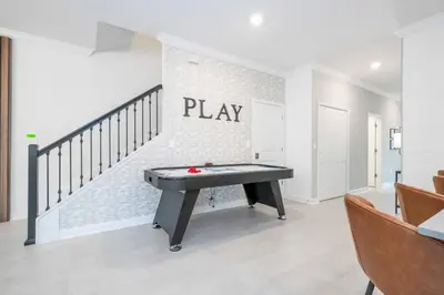 a ping pong table in a room with a staircase at Stunning 5 Bd w Pool at Storey Lake Resort 2400 in Kissimmee