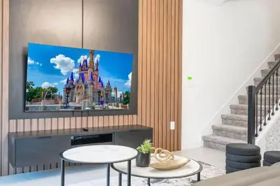 a living room with a disney castle on the tv screen at Stunning 5 Bd w Pool at Storey Lake Resort 2400 in Kissimmee