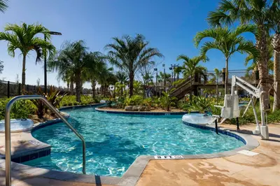 a pool at a resort with palm trees at Stunning 4 Bd w Pool @ Storey Lake Resort 2613 in Kissimmee