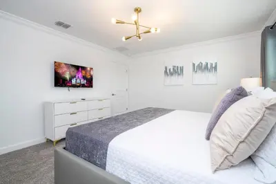 a white bedroom with a bed and a ceiling fan at Stunning 4 Bd w Pool @ Storey Lake Resort 2613 in Kissimmee