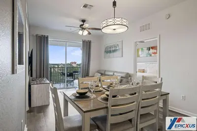 a dining room and living room with a table and chairs at The Epic Edinburgh Top Floor Vista Cay Orlando in Orlando