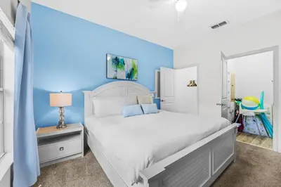 a bedroom with a white bed and a blue wall at Home with a pool at Storey Lake Resort in Kissimmee