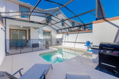 a house with a swimming pool and a grill at Family 4BR w Private Pool near Disney Parks in Kissimmee