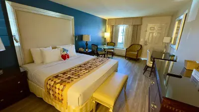 a hotel room with a large bed and a table at Hotel Monte Carlo in Kissimmee