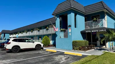 a white car parked in front of a hotel building at Hotel Monte Carlo in Kissimmee