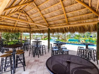an outdoor patio with tables and chairs and a pool at Makin Memories Gated Resort Style Community Storey Lake in Kissimmee