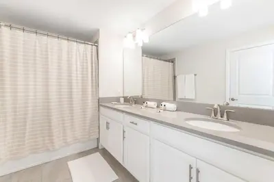 a bathroom with two sinks and a large mirror at Disney Dream Home Prime Location Private Pool in Kissimmee