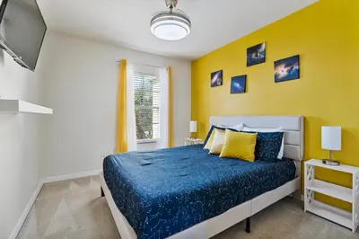 a bedroom with a bed and a yellow wall at Amazing 3Bdrms At Encantada- 6 miles from Disney in Kissimmee