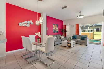 a living room with a red wall at Amazing 3Bdrms At Encantada- 6 miles from Disney in Kissimmee