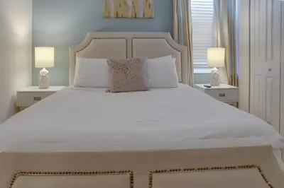 a bedroom with a large white bed with two lamps at Summer Escape - Spacious 8BR Home with Private Pool! in Kissimmee