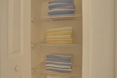 a closet with four towels sitting on shelves at Summer Escape - Spacious 8BR Home with Private Pool! in Kissimmee