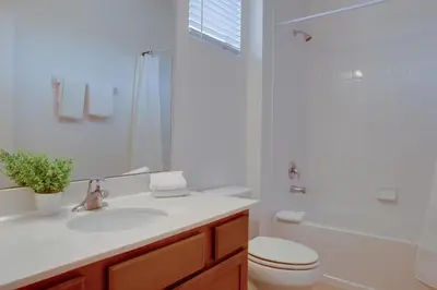 a bathroom with a sink and a toilet and a shower at Summer Escape - Spacious 8BR Home with Private Pool! in Kissimmee