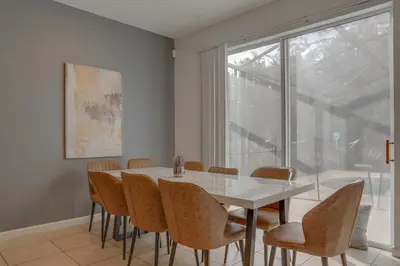 a dining room with a table and chairs and a window at Summer Escape - Spacious 8BR Home with Private Pool! in Kissimmee
