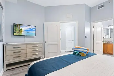 a bedroom with a bed with a tv on the wall at Lakeview newly renovated condo near Disney in Orlando