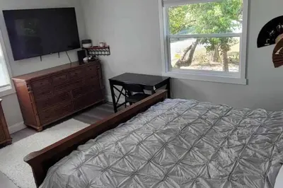 a bedroom with a bed and a flat screen tv at House close Baldwin-park Lake & Downtown Orlando in Orlando