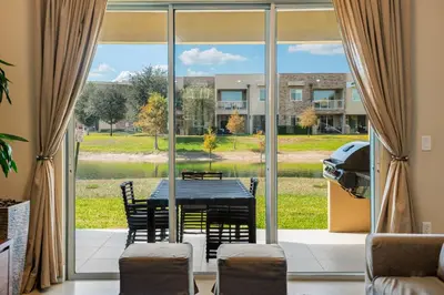 a dining room with a table and chairs in front of a window at 4 BR Home w/ Resort Amenities + 3 Mi to Disney in Orlando