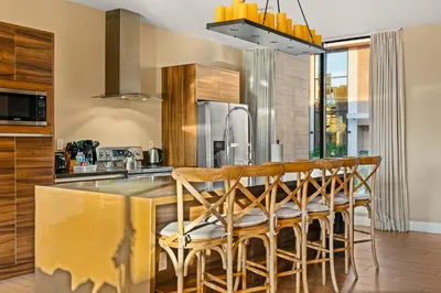 a kitchen with a bar with wooden stools at Outdoor Kitchen + 8 Min to Disney + Resort Cabanas in Orlando