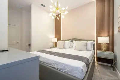 a bedroom with a large bed and a chandelier at 6163 Fantastic Home with 12BD in Orlando