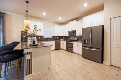 a large kitchen with stainless steel appliances at Incredible 6BR Villa by Disney Private Pool Games in Kissimmee