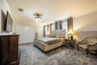 a bedroom with a bed and a chair at Incredible 6BR Villa by Disney Private Pool Games in Kissimmee