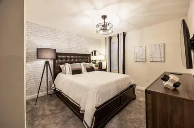a bedroom with a large bed and a dresser at Incredible 6BR Villa by Disney Private Pool Games in Kissimmee