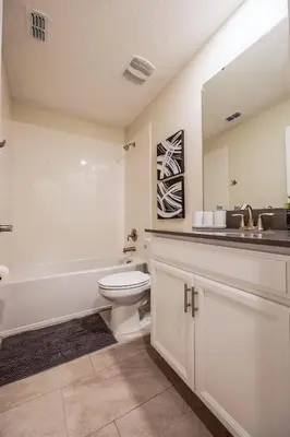 a bathroom with a toilet and a sink and a tub at Incredible 6BR Villa by Disney Private Pool Games in Kissimmee