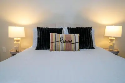 a bedroom with a white bed with two lamps at New Exclusive Villa 5 min to Disney in Orlando