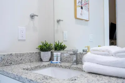 a bathroom with a sink and a mirror and towels at New Exclusive Villa 5 min to Disney in Orlando