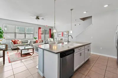 a kitchen with a sink and a living room at Amazing 4BdrmsPrivate Hot Tub7 miles from Disney in Kissimmee