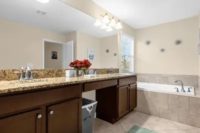 a bathroom with two sinks and a bath tub and a sink at Perfect Disney Holiday! Private Pool, Spa, Resort! in Kissimmee