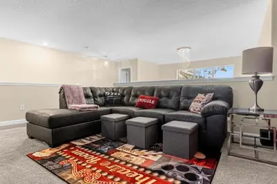 a living room with a black leather couch at Perfect Disney Holiday! Private Pool, Spa, Resort! in Kissimmee