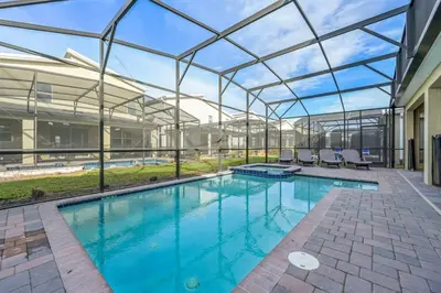 an indoor swimming pool with a glass roof at Charming Home Ideal Location Spacious Game Room in Kissimmee