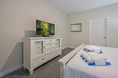 a bedroom with a bed and a television on a dresser at Charming Home Ideal Location Spacious Game Room in Kissimmee