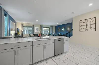 a large kitchen with white cabinets and a dining room at Charming Home Ideal Location Spacious Game Room in Kissimmee