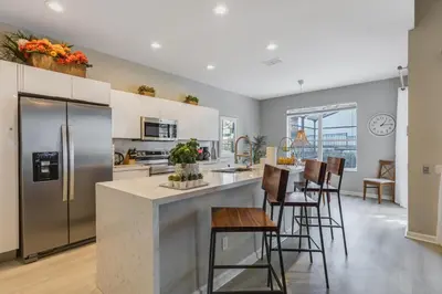 a kitchen with stainless steel appliances and a bar with stools at Hibiscus Villa in Orlando