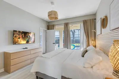 a white bedroom with a large bed and a window at Hibiscus Villa in Orlando