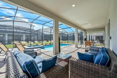 an indoor patio with blue furniture and a swimming pool at Disney Bliss Themed Rooms Game Room Private Pool in Kissimmee