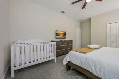 a bedroom with a crib and a dresser at Disney Bliss Themed Rooms Game Room Private Pool in Kissimmee