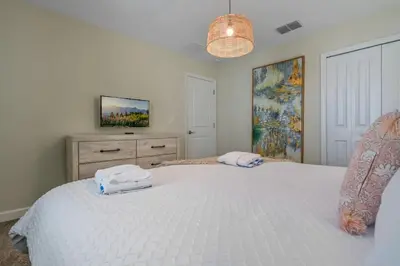 a bedroom with two white towels on a bed at Disney Bliss Themed Rooms Game Room Private Pool in Kissimmee