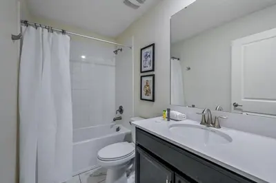 a white bathroom with a sink and a toilet at Disney Bliss Themed Rooms Game Room Private Pool in Kissimmee
