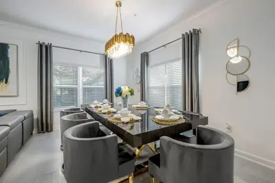 a dining room with a glass table and chairs at Luxury Chic Modern Home Prime Location in Kissimmee