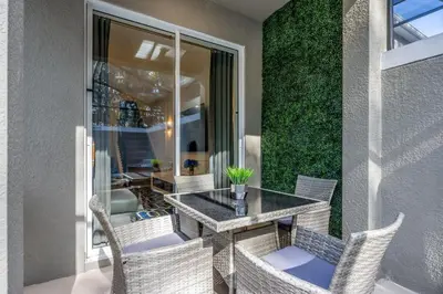 a patio with a table and wicker chairs at Luxury Chic Modern Home Prime Location in Kissimmee
