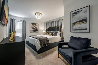 a bedroom with a bed and a chair at Luxury Chic Modern Home Prime Location in Kissimmee
